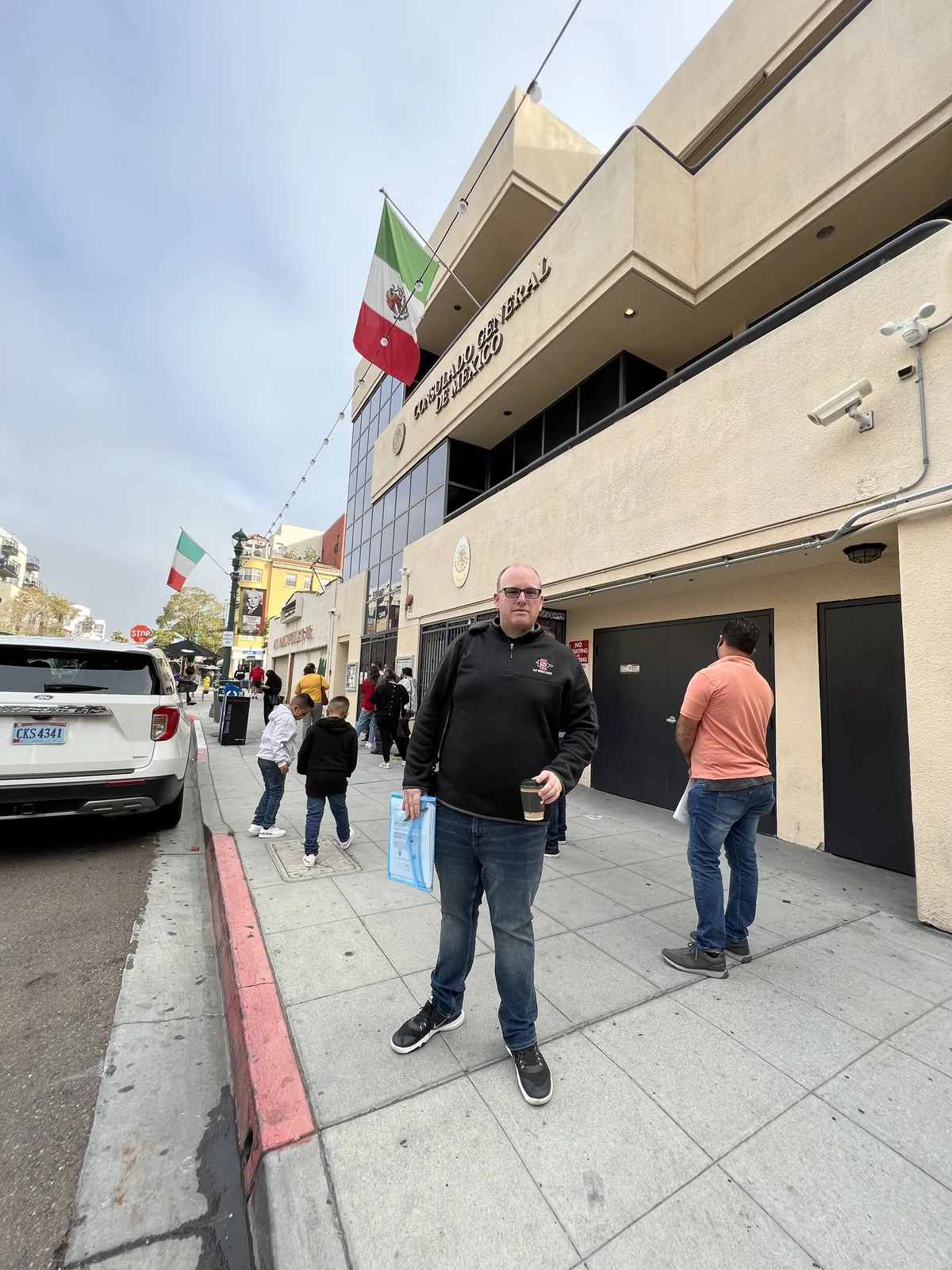 Michael holding his Mexican temporary residency card outside the consulate