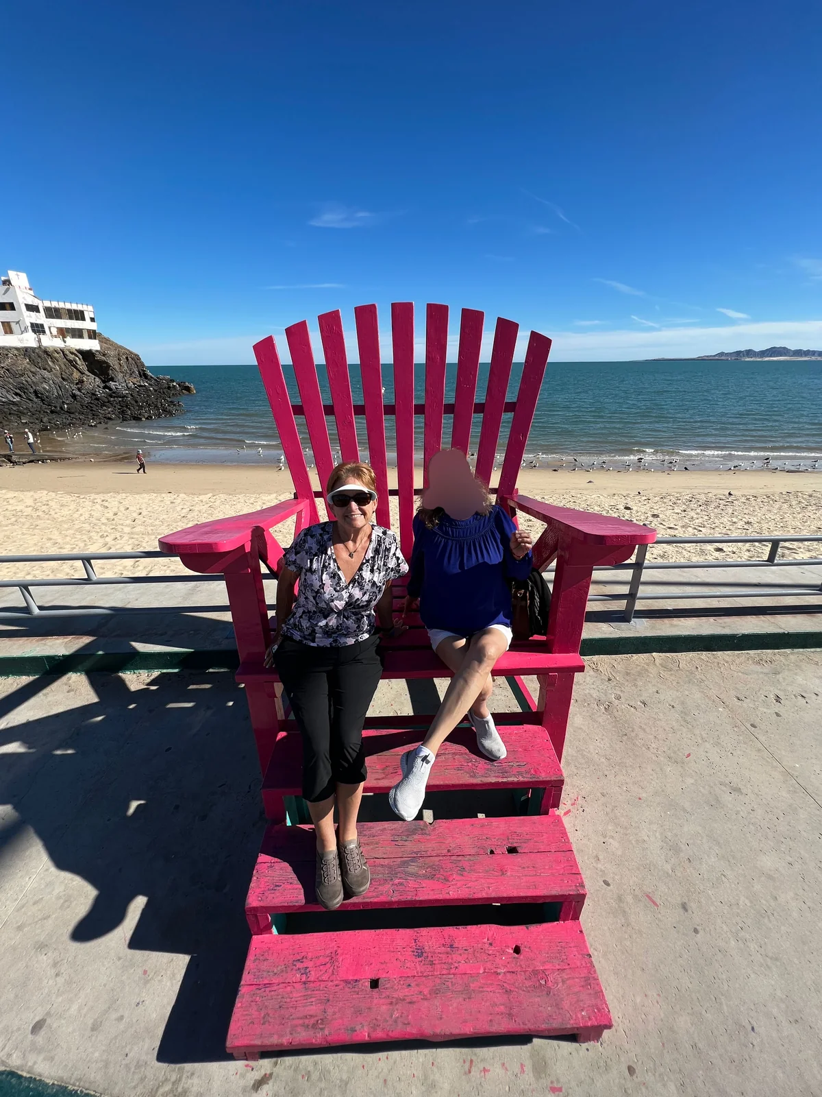 The two moms in the giant red chair at San Felipe beach, Thanksgiving 2023 — two women who couldn't share a language and didn't need to